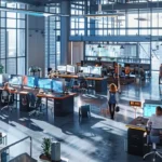 a bustling urban office space filled with modern furniture and vibrant colors, showcasing focused professionals collaborating around sleek workstations in a dynamic atmosphere.