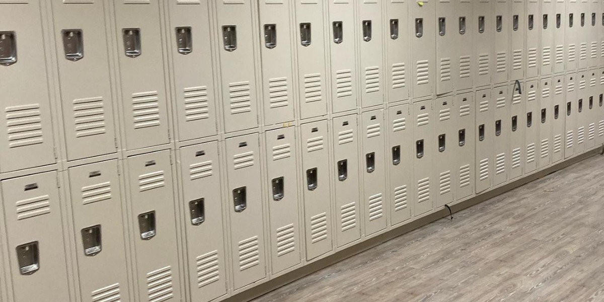 A long row of tan metal lockers in two tiers along a wall with wood-look flooring.
