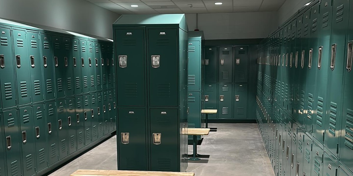 A long row of tan metal lockers in two tiers against a white wall with light-colored tile flooring.