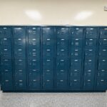 Blue metal storage lockers in a clean indoor hallway.